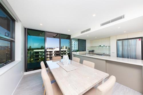 a kitchen and dining room with a table and chairs at The Strand 602 in Forster