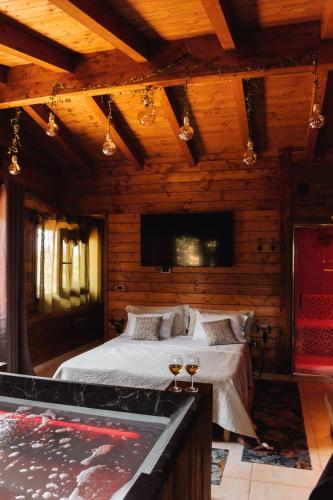 a bedroom with a bed with two glasses of wine at Mini spa in chalet bosco in Cisternino