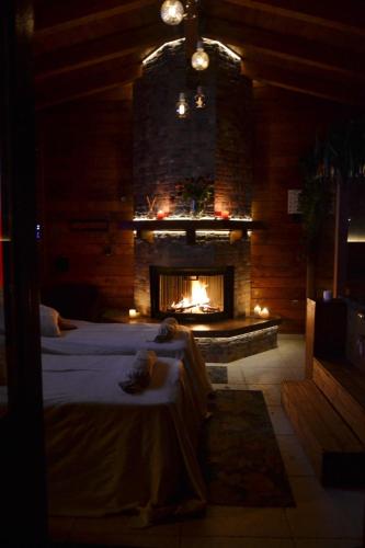 a room with a fireplace and a bed in front of it at Mini spa in chalet bosco in Cisternino