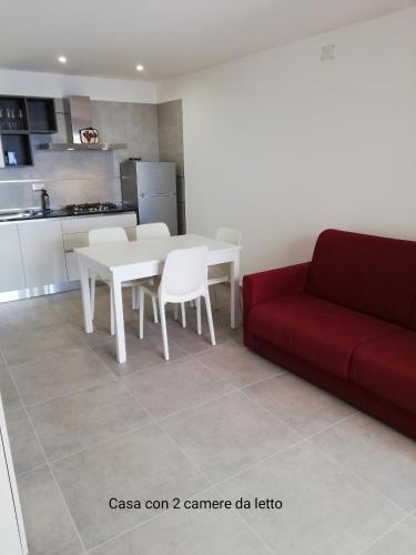 a living room with a white table and a red couch at Fascino del Cilento in Caprioli