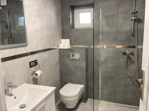 a bathroom with a shower and a toilet and a sink at Guest House Ustka in Ustka