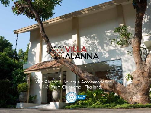 un edificio con un árbol delante de él en Villa ALANNA, en Chiang Mai