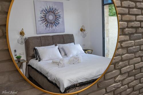 a mirror reflecting a bed with two teddy bears on it at מלכה בעתיקה in Safed