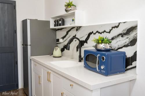 a kitchen with a sink and a microwave on a counter at מלכה בעתיקה in Safed