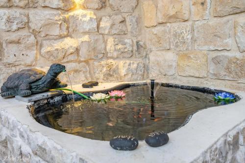 a bird statue sitting next to a water fountain at מלכה בעתיקה in Safed