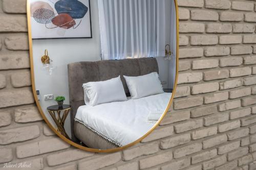 a mirror on a brick wall with a bed at מלכה בעתיקה in Safed