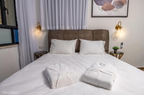 a bedroom with a bed with two towels on it at מלכה בעתיקה in Safed