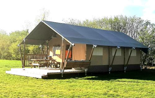 a tent with a table and chairs in a field at Safaritent Lodge 5 in Ruurlo