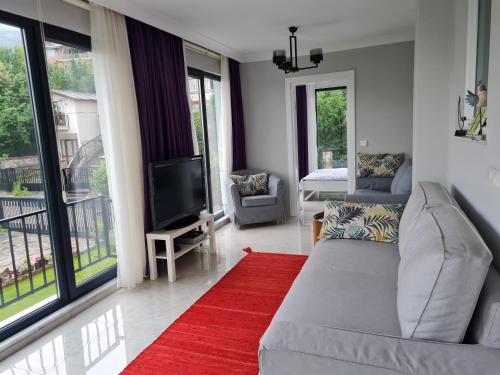 KD Apartments في كارتيبي: غرفة معيشة بها أريكة وتلفزيون