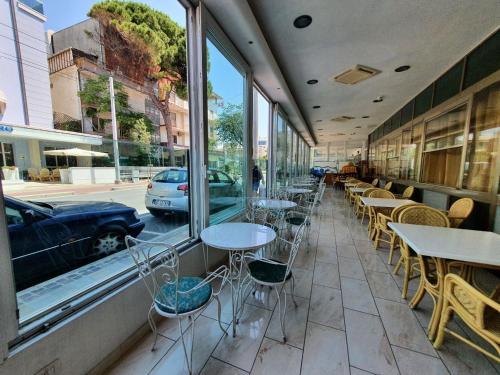 una fila de mesas y sillas fuera de un restaurante en Hotel Moresco - Piscina Beach Village, en Riccione