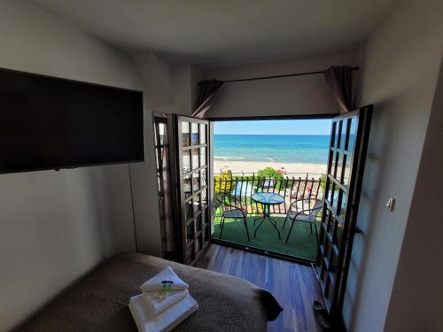 a bedroom with a bed and a view of the beach at Dom Przy Plaży in Sarbinowo