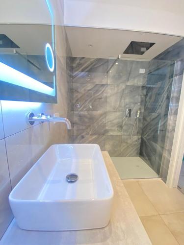 a white sink in a bathroom with a shower at Koralline accommodation in Tropea
