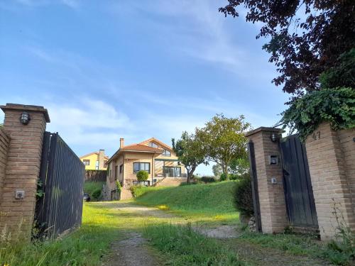 a house with a gate in a yard at Chalet en Quintueles afueras de Gijón Asturias in Quintueles