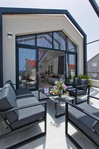a patio with a couch and chairs and a table at La Siesta - ZF Hvar in Hvar