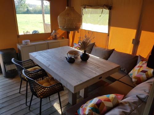 una mesa de madera en una sala de estar con sofá en Safaritent Lodge 5 en Ruurlo