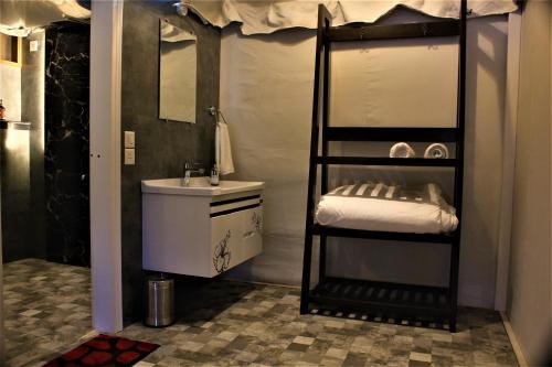 a bathroom with a bunk bed and a sink at The Bugyal in Kanatal