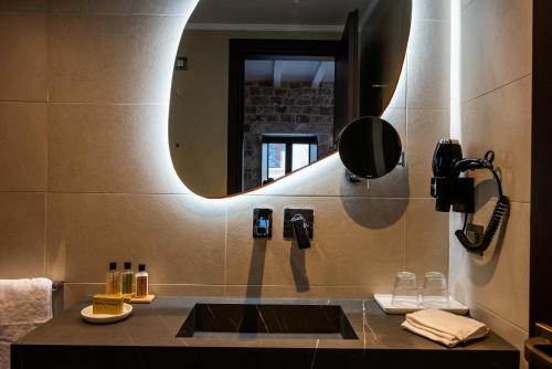 a bathroom with a sink and a mirror at Manifest Boutique Hotel in Oitylo
