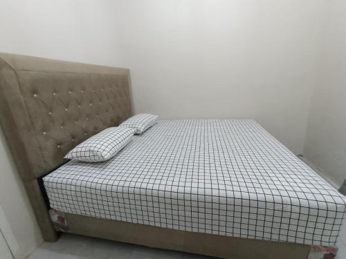 a bed with two pillows on it in a room at Guest House Gani Syariah in Paret