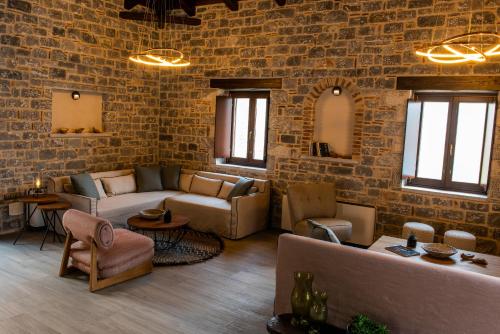 a living room with brick walls and couches and chairs at Manifest Boutique Hotel in Oítilon