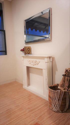 a white fireplace with a mirror on top of it at SOWAN BOUTIQUE GUEST HOUSE in Ngadipuro