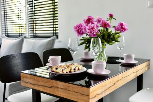 a table with a plate of food and flowers on it at Apartament Ogrodowy Zakątek in Uniejow