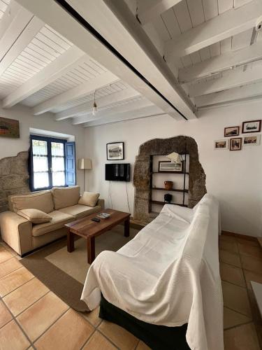 a living room with a bed and a couch at Pexe na mar in Lastres