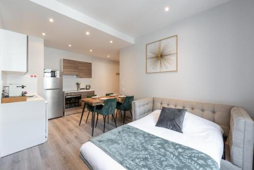 une chambre avec un lit et une cuisine avec une table dans l'établissement LE POMPADOUR - Magnifique T2 Place Bellecour 4ème étage sans ascenseur - 4th floor no elevator, à Lyon