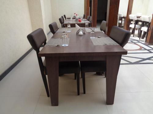 a dining room table with chairs and a table with wine glasses at ICONIC Hotel Digha in Digha