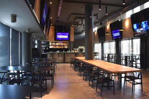 a dining room with tables and chairs and televisions at Mayfair Hotel in Paphos City