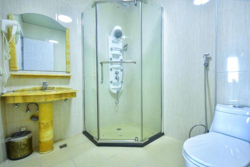 uma casa de banho com um chuveiro, um WC e um lavatório. em Hotel Chveni Sakhli em Batumi