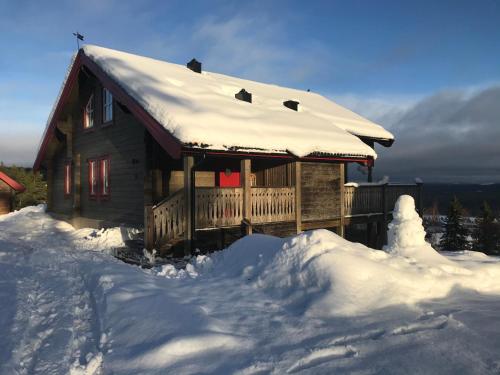 Cabaña de madera con nieve en el suelo en Alpstigen 10B - Newly built sports cottage with lovely views (lower apt), en Järvsö