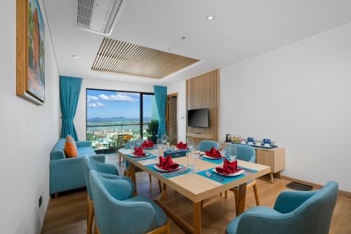 a living room with a table and blue chairs at Sala Grand Tuy Hoa Hotel in Tuy Hoa