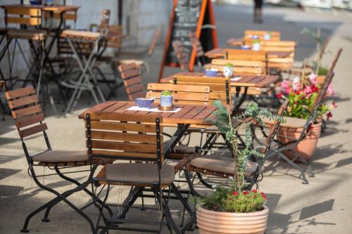 een rij houten tafels en stoelen met bloemen bij Ancora Faros in Stari Grad