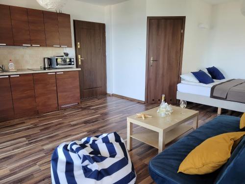 a small living room with a bed and a table at Dom Przy Plaży in Sarbinowo