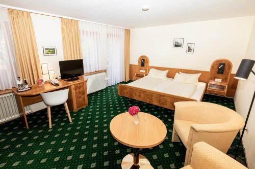 a hotel room with a bed and a desk at Landhaus Lauble in Hornberg