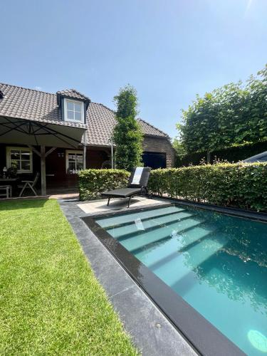 a swimming pool in the yard of a house at Blauwe Lucht in Deurne