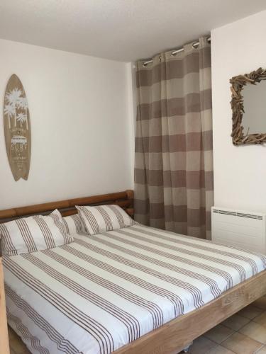 - une chambre avec un lit doté d'un matelas rayé dans l'établissement Maison zen, à Moliets-et-Maa