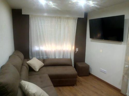 Casa o Cantón : غرفة معيشة مع أريكة وتلفزيون بشاشة مسطحة