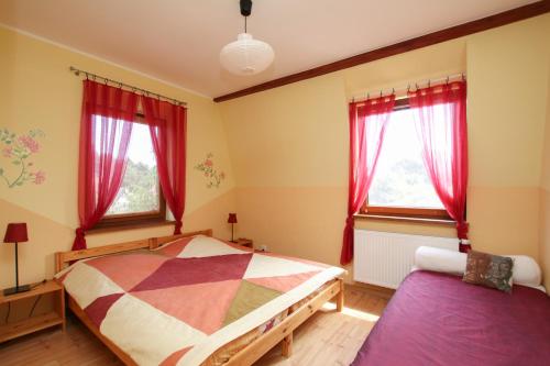 a bedroom with a bed and two windows at Apartment 4 in Rewal