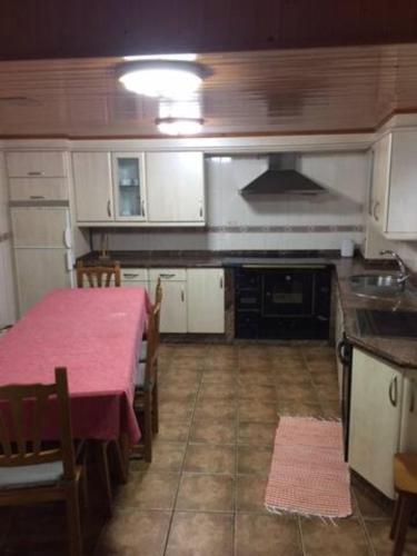 una cucina con tavolo e tovaglia rosa di Casa o Cantón a Berredo