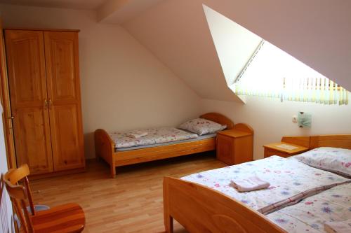 a attic bedroom with two beds and a window at Apartments Jožetov grič - FARM STAY in Podčetrtek