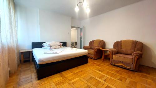 Habitación hospitalaria con 1 cama y 2 sillas en The Home, en Hunedoara