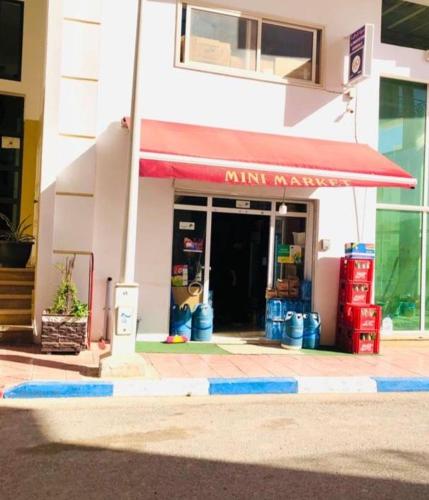 a shop with a red awning in a building at L impérial appart founty in Agadir
