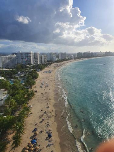 an aerial view of a beach with people and the ocean at Sea breeze vacation ll en Condominio Verde Mar in San Juan