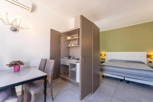 a bedroom with a bed and a table and a desk at Villa Mosca Charming House in Alghero