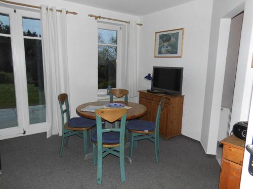 a dining room with a table and chairs and a television at 54 Appartement Residenz Bellevue U in Zinnowitz