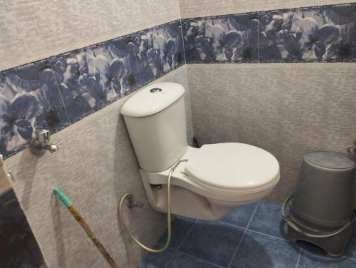 a bathroom with a toilet and a trash can at Sharada Home Stay in Chandrāpuri