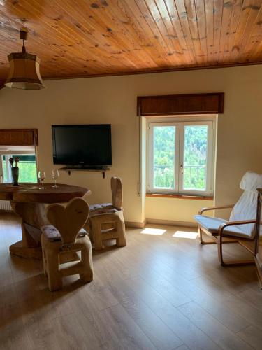 a living room with a television and a table and chairs at La Mansarda di Casa Vacanze La Vite in Bordogna