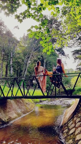 deux femmes assises sur un pont sur une rivière dans l'établissement Bürgerhaus auf dem Hasenberg, à Gützkow