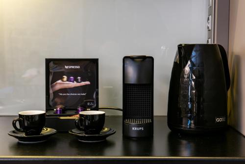 a coffee maker and two cups on a table at Manifest Boutique Hotel in Oítilon
